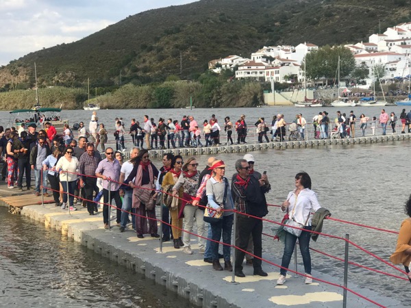 Multitud cruzando pasarela flotante